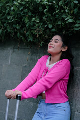 Serene traveler pauses by ivy-covered wall, embracing a moment o