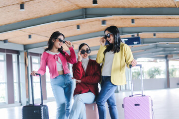 Stylish travelers on the move, Three female friends showcase a b