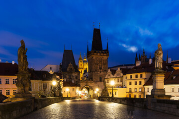 Charles Bridge without people in the morning in the blue hour, Malostranska Bridge Tower, the dominant feature of Charles Bridge. The illuminated Charles Bridge