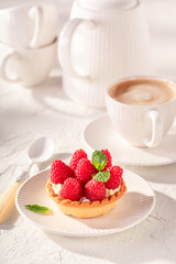 Tasty and homemade mini tart made of cream and raspberries.