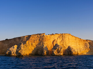 Golden cliffs rising from blue sea in Koufonisi island Aegean