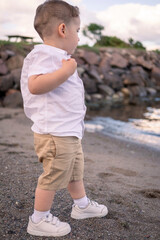 Child enjoying a quiet beach afternoon. little boy walking on the beach.
