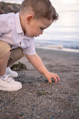 Little boy playing with sand on the beach.
