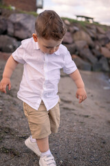 Child enjoying a quiet beach afternoon. little boy walking on the beach.