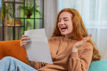 Happy redhead woman open envelope letter, reading it. Career growth advance promotion, bank loan...