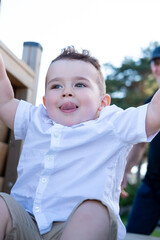 Smiling boy on the playground sticking out his tongue.