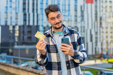 Middle-aged mature man using credit card smartphone while transferring money purchases online...