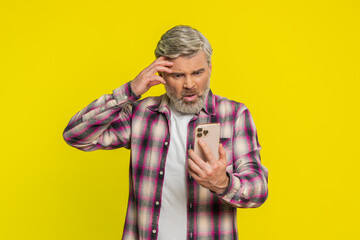 Upset sad Caucasian mature man use smartphone typing browsing, play game, loses, surprised by...