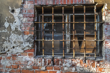 rusty bars on the window old building ruin, damaged brick wall