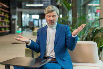 What. Why. Angry Caucasian businessman raising hands in indignant expression, asking reason of...