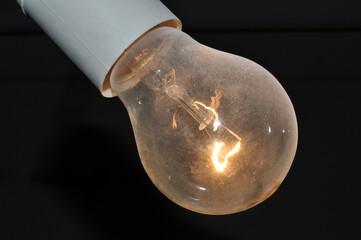 naked dusty light bulb glows electricity