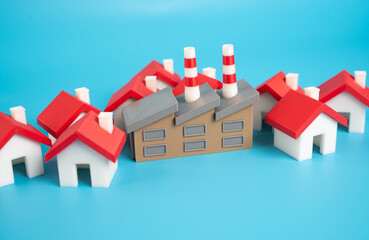 An industrial plant surrounded by houses. Public demand for the removal of dirty and noisy industry outside the growing area of the city. Pushback against pollution, noise, zoning laws
