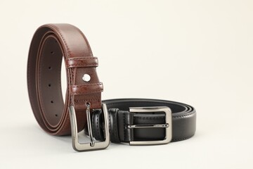 Two leather belts on white background, closeup