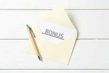 Envelope, card with word Bonus and pen on white wooden table, top view