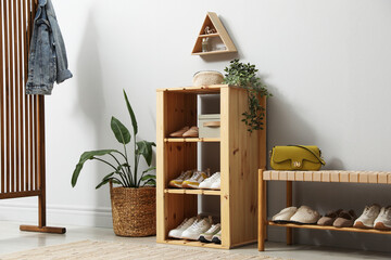 Different footwear on shelves in entryway. Shoe storage