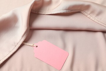 Cardboard tag on silk garment, top view