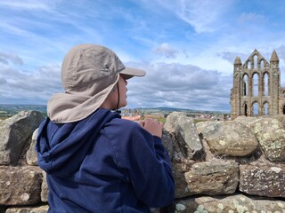 Boy 8 looking at the Whitby Abbey, summer 2025 beautiful clear day in North Yorkshire England UK