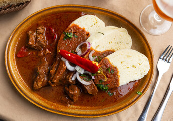 Meat goulash with onions, red hot pepper. Served with bread and gravy. Slovak cuisine