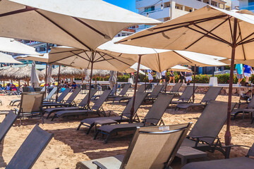 Chairs with tables under umbrellas on the beach facing the sea, in Puerto Vallarta, Jalisco