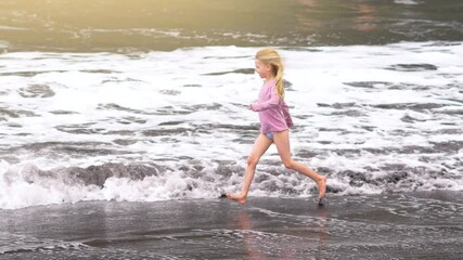Joyful moments of a child running through shallow waves at the beach on a sunny summer vacation day