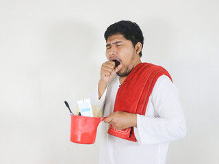 A handsome Asian man is taking a bath and carrying toiletries placed on the ladle he is holding,...