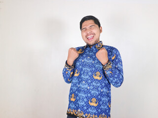 Indonesian civil servant man shows gesture of achieving success and victory with a happy face, and...