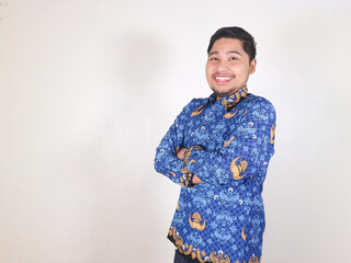 Indonesian civil servant man standing with a happy and friendly expression while folding his hands....