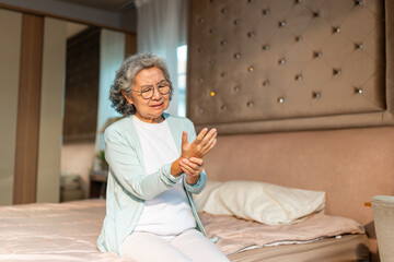 Asian senior woman massaging hand, suffering from finger wrist hand pain. Elderly people health...