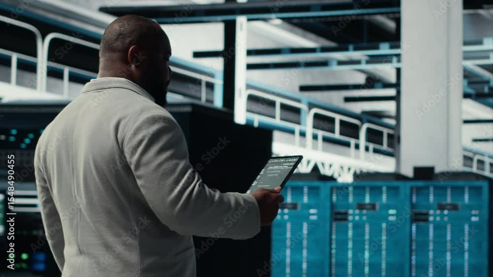 Poster data center technician using laptop to manage software updates for system stability. african america