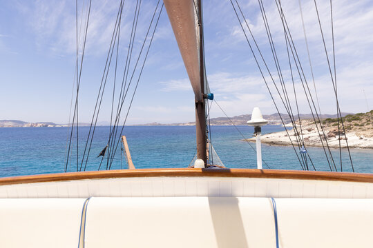 deck of cruise ship or luxury yacht during a bright summer day with clear blue sky and islands in the distance.