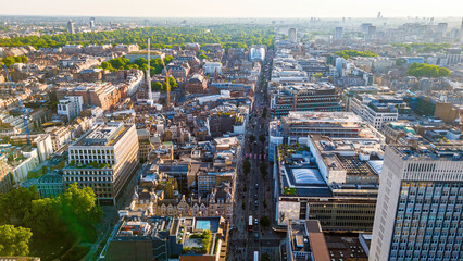 Aerial view of Oxford Circus in London with busy streets, iconic architecture, and red double-decker buses on a clear, sunny day