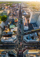 Aerial view of Oxford Street in London with bustling traffic, classic buildings, and red double-decker buses on a sunny, clear day.