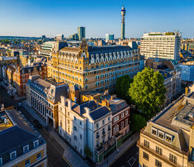 Aerial view of Cavendish Square Gardens in London surrounded by classic architecture, roads, and vehicles on a bright summer day.