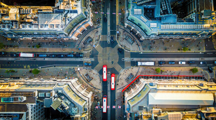 Aerial view of Oxford Circus in London with busy streets, iconic architecture, and red double-decker buses on a clear, sunny day