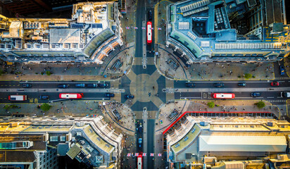 Aerial view of Oxford Circus in London with busy streets, iconic architecture, and red double-decker buses on a clear, sunny day