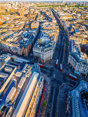 Aerial view of Oxford Circus in London with busy streets, iconic architecture, and red double-decker buses on a clear, sunny day