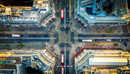 Aerial view of Oxford Circus in London with busy streets, iconic architecture, and red double-decker buses on a clear, sunny day