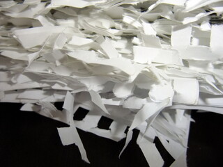 Shredded white paper pieces scattered in a chaotic arrangement, showcasing texture and detail,...
