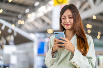 Smiling young woman talking on mobile phone at airport terminal, happy traveler staying connected...