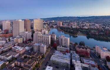 Obraz premium Aerial view of Oakland, California, USA, at dusk. The photo shows Lake Merritt, downtown buildings, and the surrounding hills. The image captures the city's urban landscape.