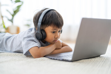 Asian boy using laptop with headphones course online learning, distance education for kids,...
