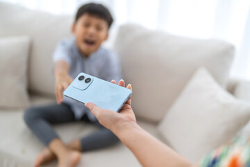 Child reaching for smartphone from parent, screen time control, tech addiction in kids, digital...