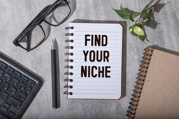 FIND YOUR NICHE. text on white paper on a gray background near glasses