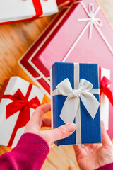 Beautifully Wrapped Gifts with Red Ribbons.Person Holding a Wrapped Gift with Red Ribbon.Hand...