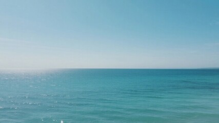 Obraz premium Tranquil expanse of ocean under a clear sky.