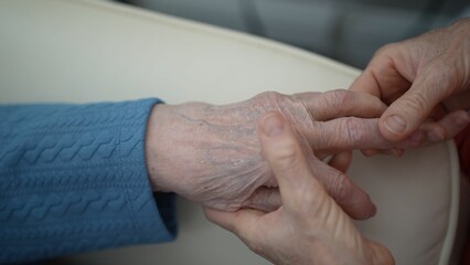 A hand massage is being performed, focusing on relaxing the fingers and palm to alleviate tension....