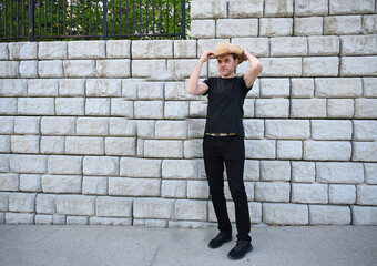 man in hat against brick wall