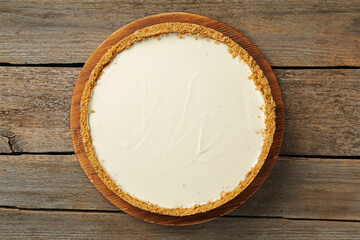 One tasty cheesecake on wooden table, top view