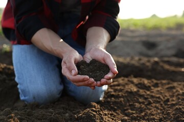 Man holding pile of soil in field, closeup