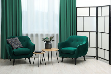 Living room with green armchairs and curtains. Interior design